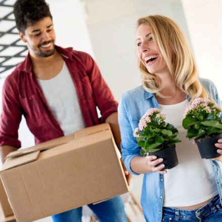 Happy couple moving houseplants